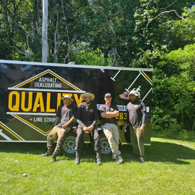 Four workers posing by trailer.