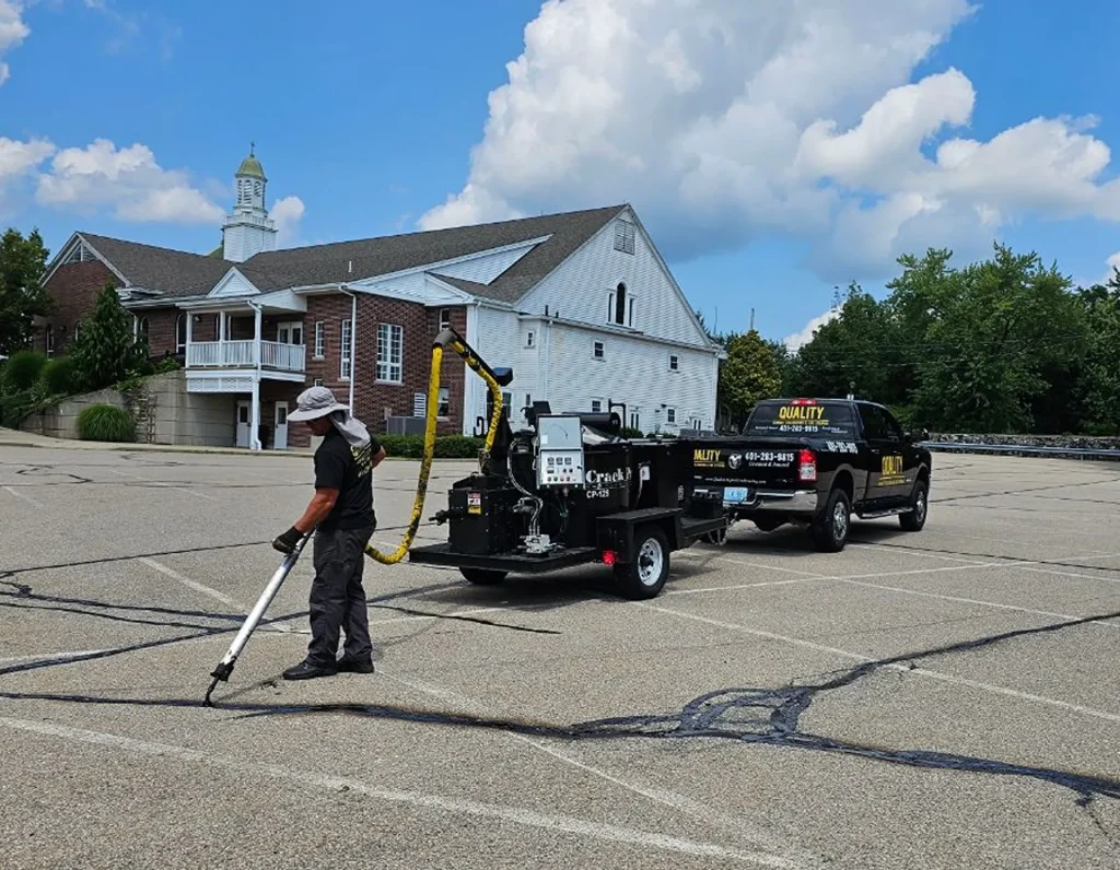 Man sealing cracks in parking lot.